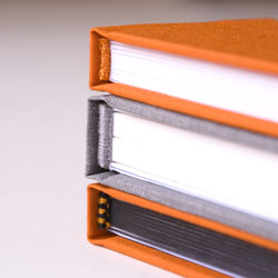 Vizuální srovnání kapitálků šitých a lepeného (shora): lepený, šitý, šitý dvoubarevný